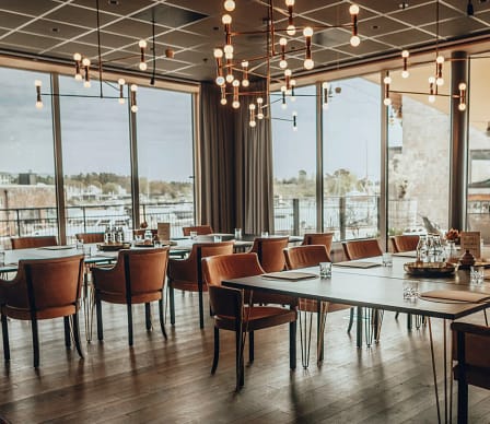 Modern konferenslokal på Slottsholmen med stora fönster, havsutsikt, eleganta lampor och bekväma stolar.