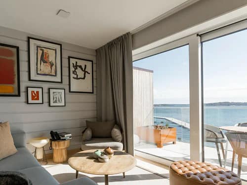 Vardagsrum i hotellsvit på Slottsholmen med stora fönster och balkong med havsutsikt.